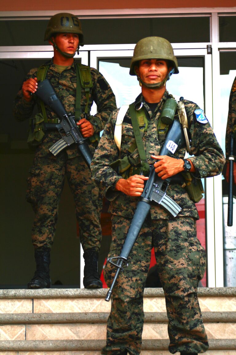 To hondurasianske soldater står med maskingæver foran en bygning i 2009. 